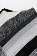 Close-up of neckline on black and grey, cotton, striped knit poncho showing texture
