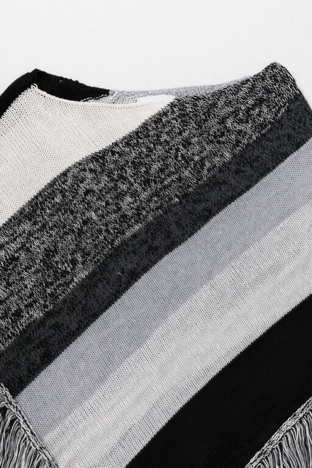 Close-up of neckline on black and grey, cotton, striped knit poncho showing texture