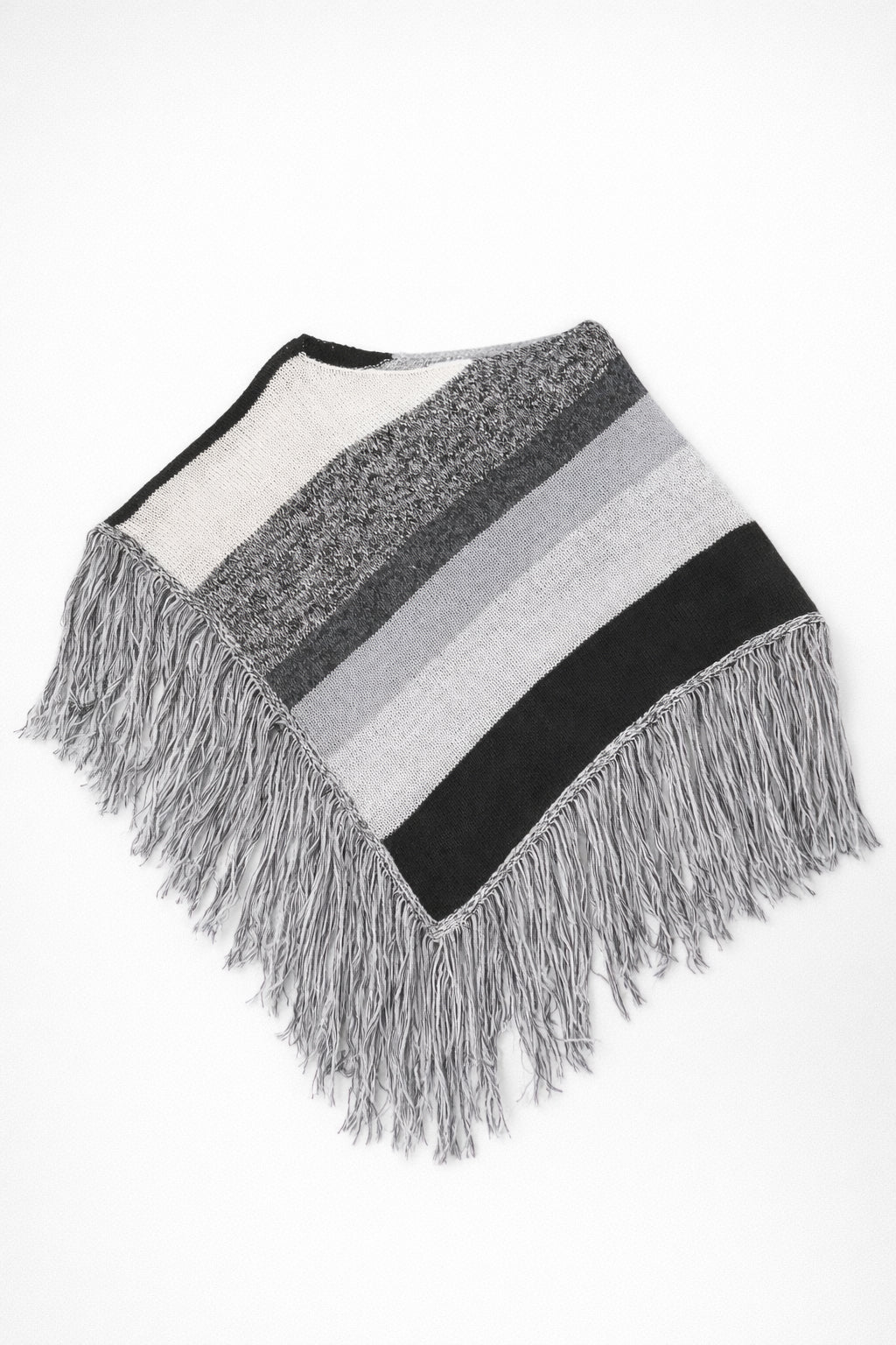 Black and grey striped knit cotton poncho with fringe laid flat on light grey background