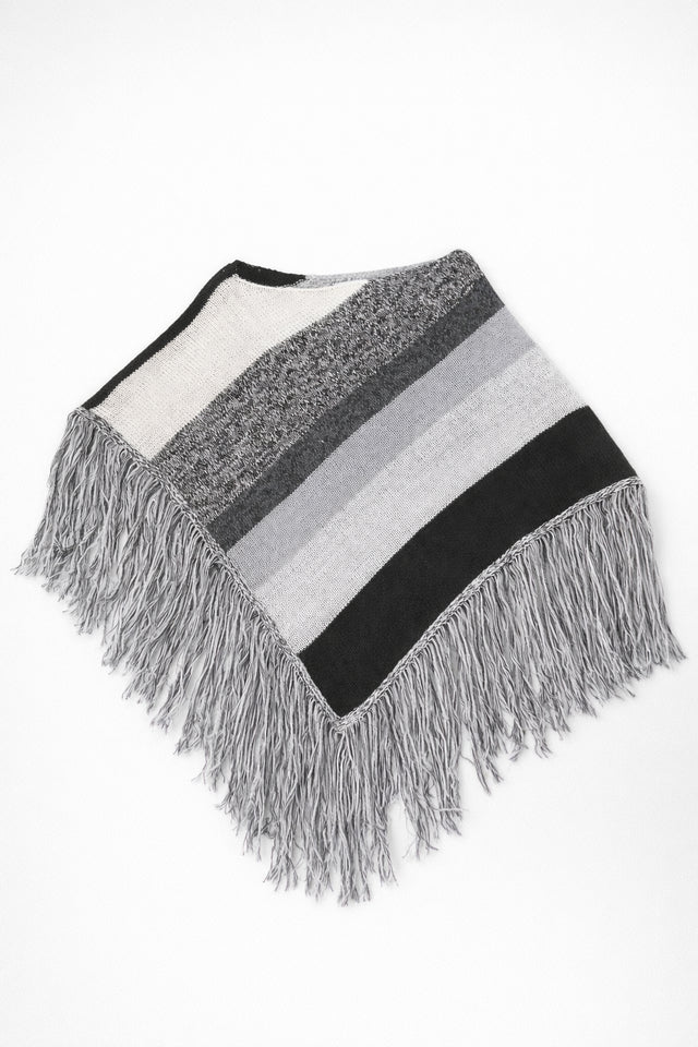Black and grey striped knit cotton poncho with fringe laid flat on light grey background
