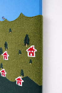 Close-up of hand loomed boucle wool textile with embroidered tree details