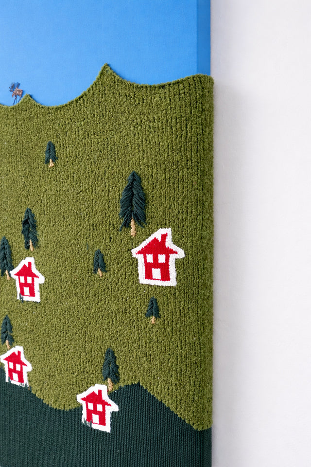 Close-up of hand loomed boucle wool textile with embroidered tree details