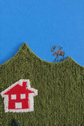 Close-up of knitted wool hillside with painted moose and textured boucle surface