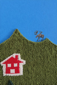 Close-up of knitted wool hillside with painted moose and textured boucle surface