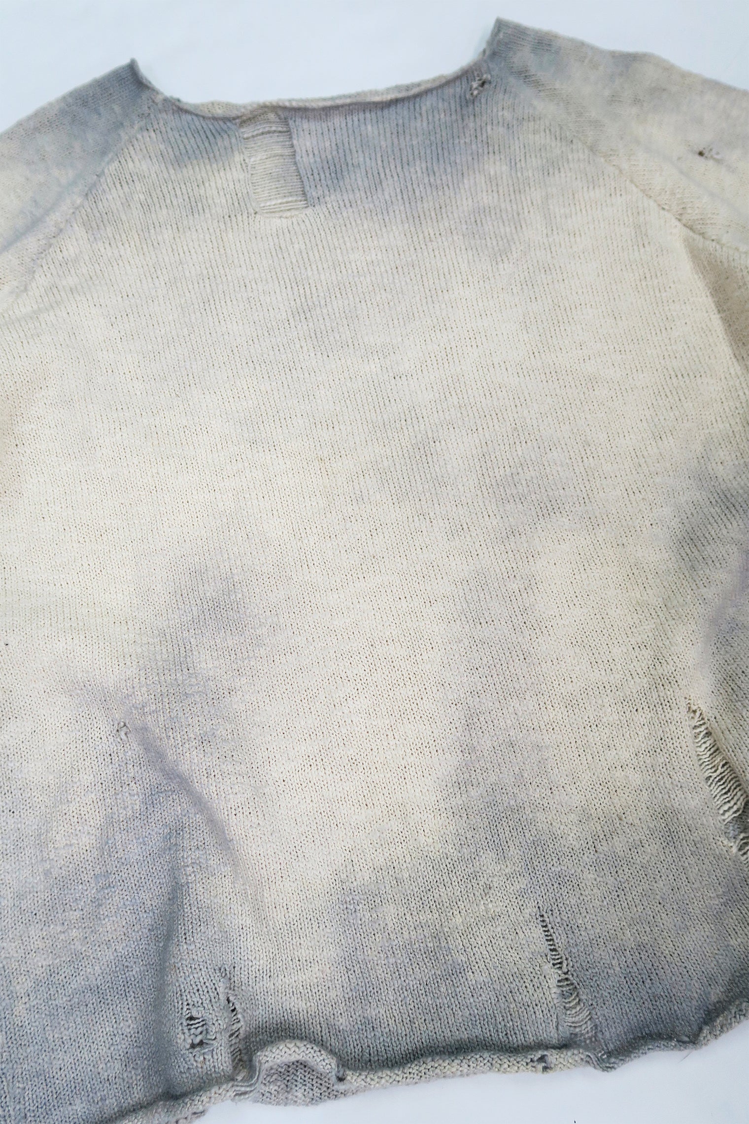 Front angle view of the archive finish raglan sweater hand loomed in slub cotton and finished with distressing and hand dye techniques.