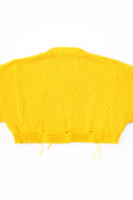 Back of the bright yellow hand loomed, cropped yellow sweater