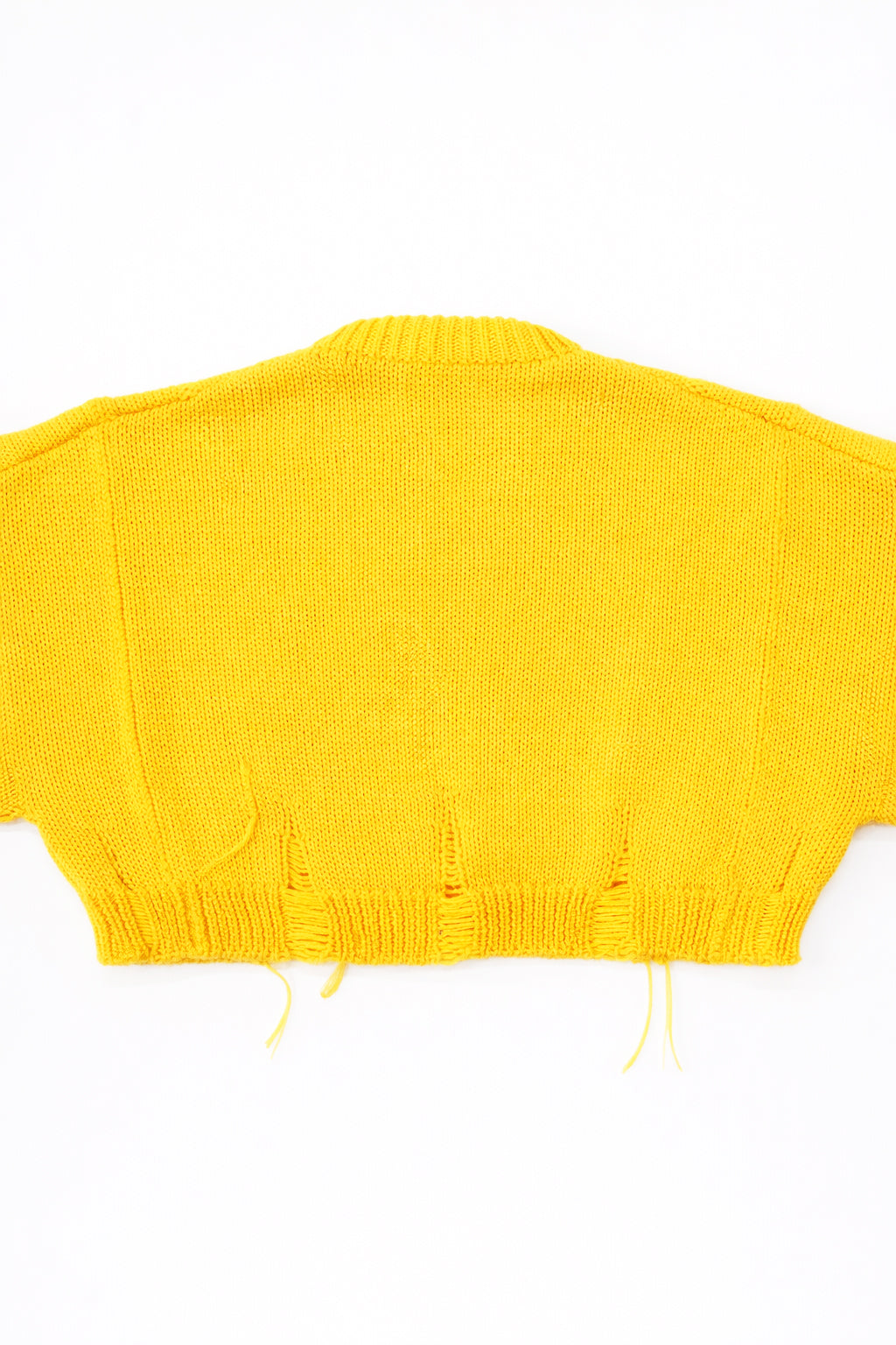 Back of the bright yellow hand loomed, cropped yellow sweater