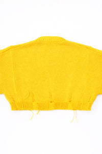 Back of the bright yellow hand loomed, cropped yellow sweater