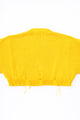 Back of the bright yellow hand loomed, cropped yellow sweater