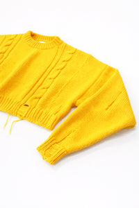 Angle detail of the hand loomed cropped cable sweater in yellow