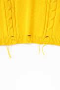 Hem detail photo of distressing on the yellow cable knit sweater hand loomed in Los Angeles