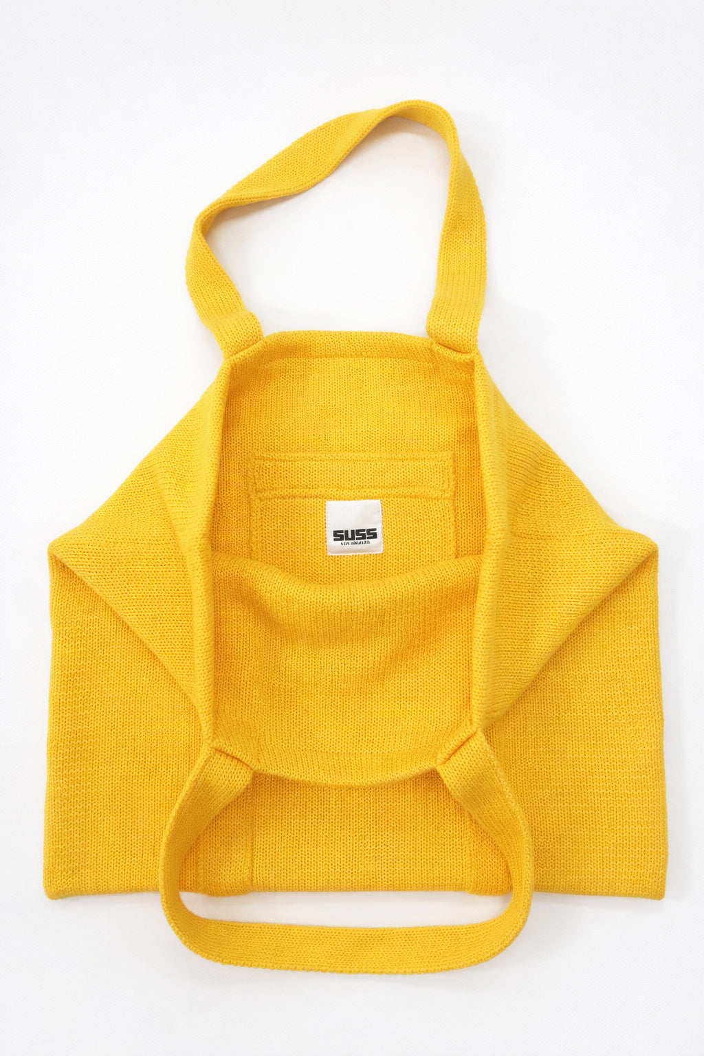 Inside of yellow knit tote bag showing thick double knit lining and interior pocket by Suss Knits