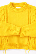 Close up of the Suss Knits yellow knit cable sweater cuffs and distressing