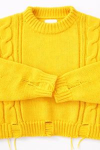 Close up of the Suss Knits yellow knit cable sweater cuffs and distressing