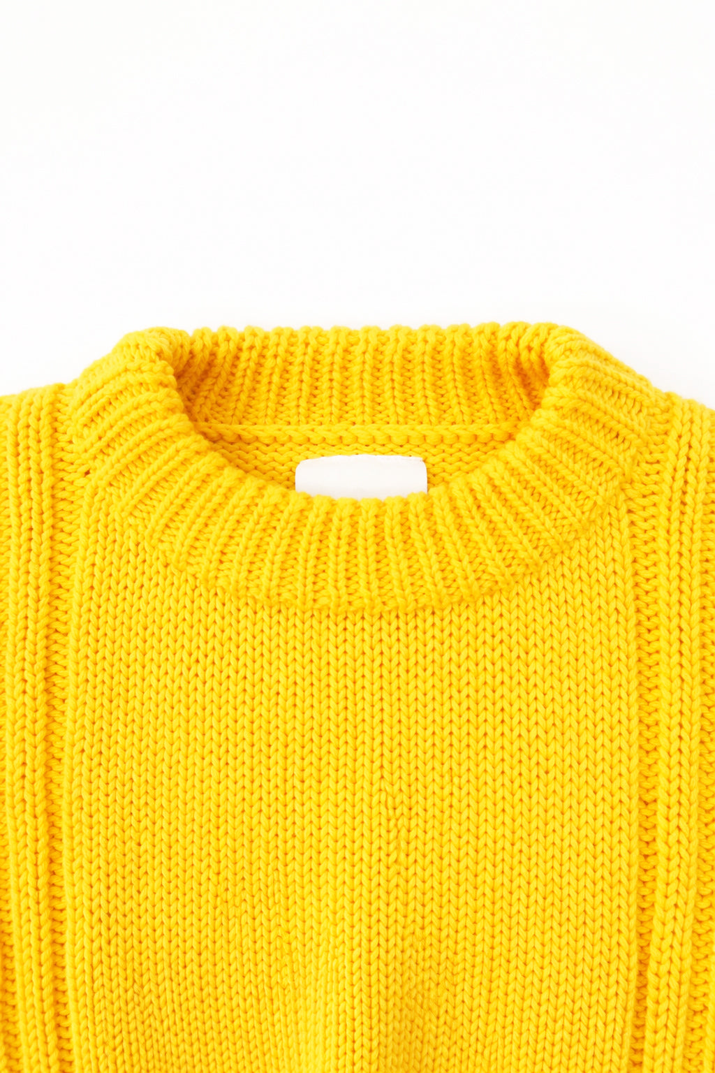 Close up detail of the knit ribbed crewneck in a yellow cotton wool blend