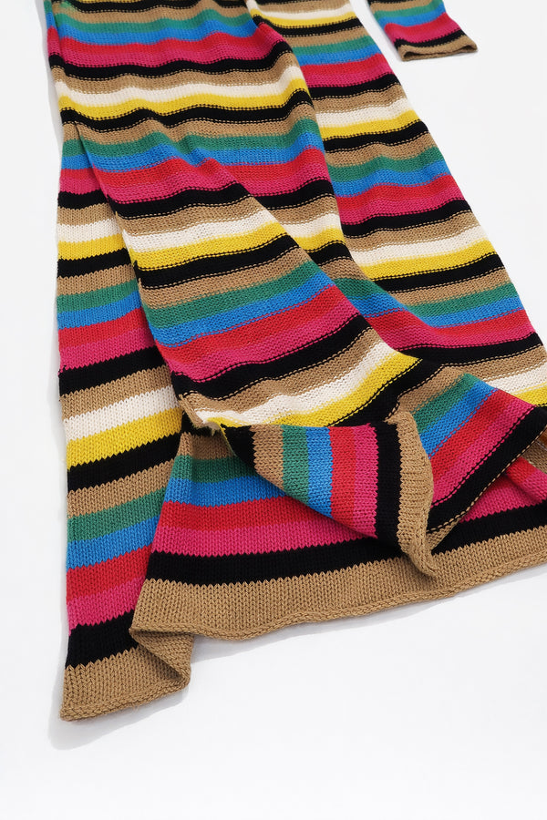 Close up of side slit and drape of multi stripe knit dress showing movement and knit structure