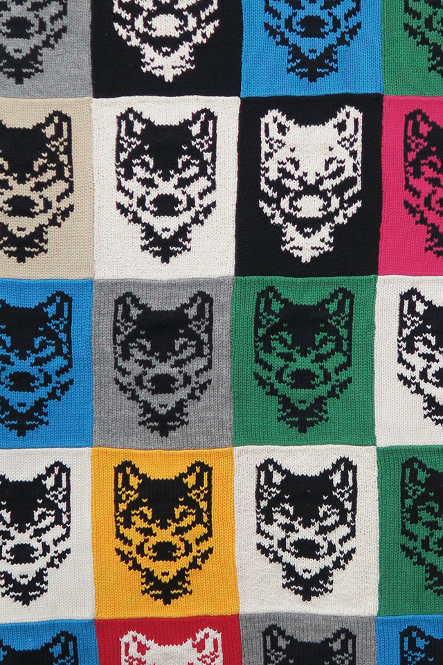 Close-up of hand-knit wolf motif panels in cotton showing texture and stitching detail