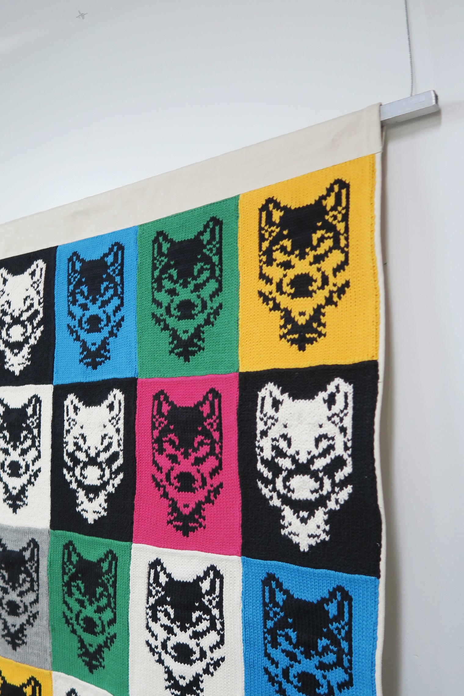 Top corner detail of fiber wall hanging with square steel rod and hanging wire system